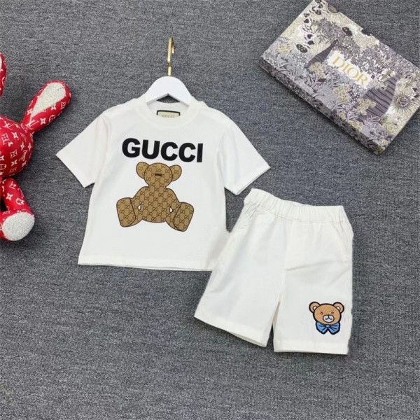  グッチGUCCI の可愛い子供用セットです。白い T シャツには大きな「GUCCI」のロゴとモノグラム柄のテディベアがデザインされ、個性的で注目を集めます子供用のサマースーツ,男の子と女の子です